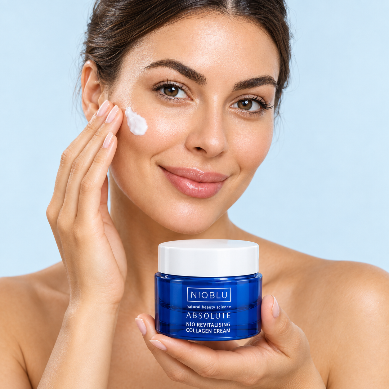 Modella che applica la crema e presenta il vaso blu NIOBLU Absolute